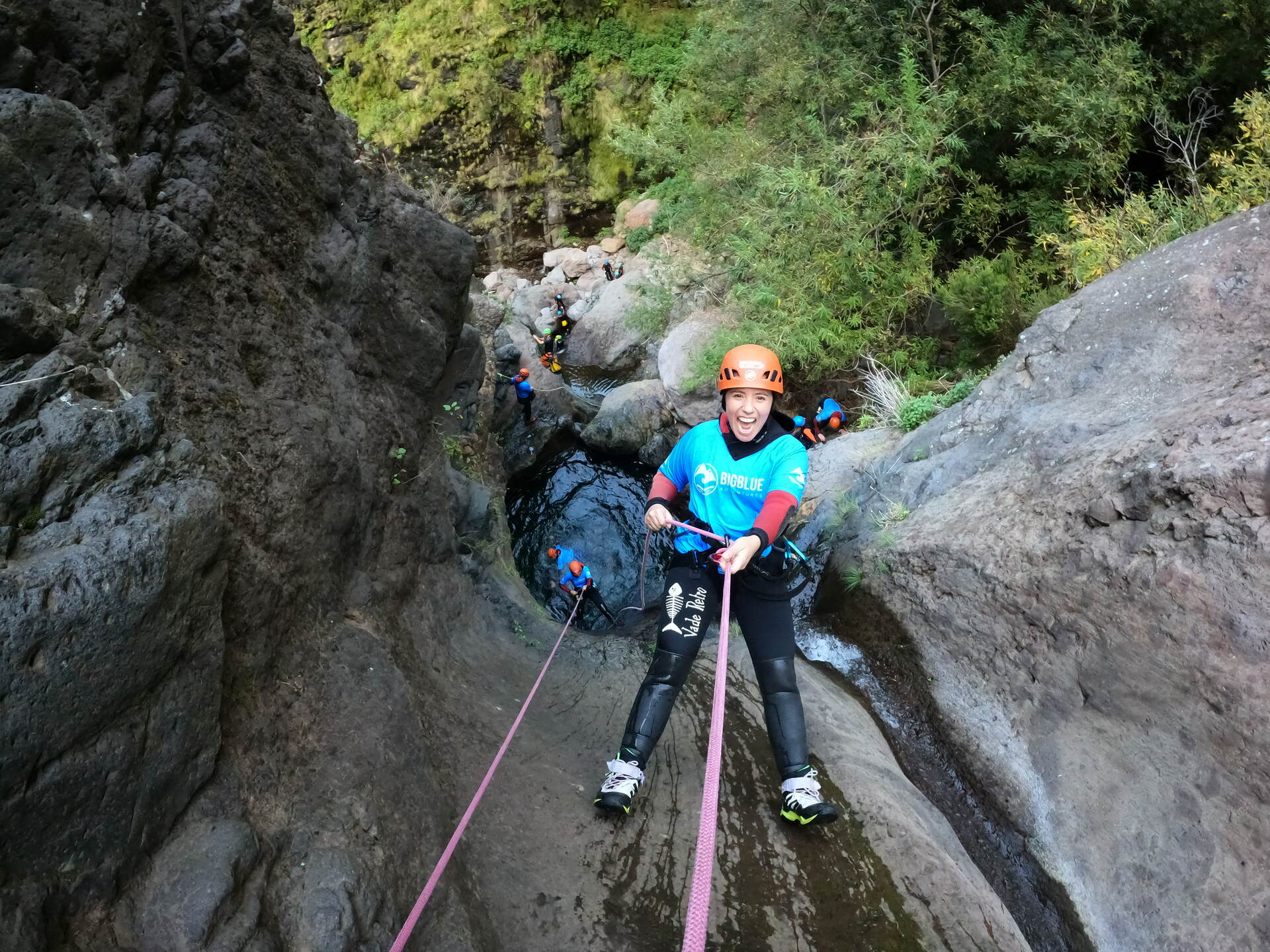 a woman abseiling down a waterfall on a canyoning activity on Madeira Island