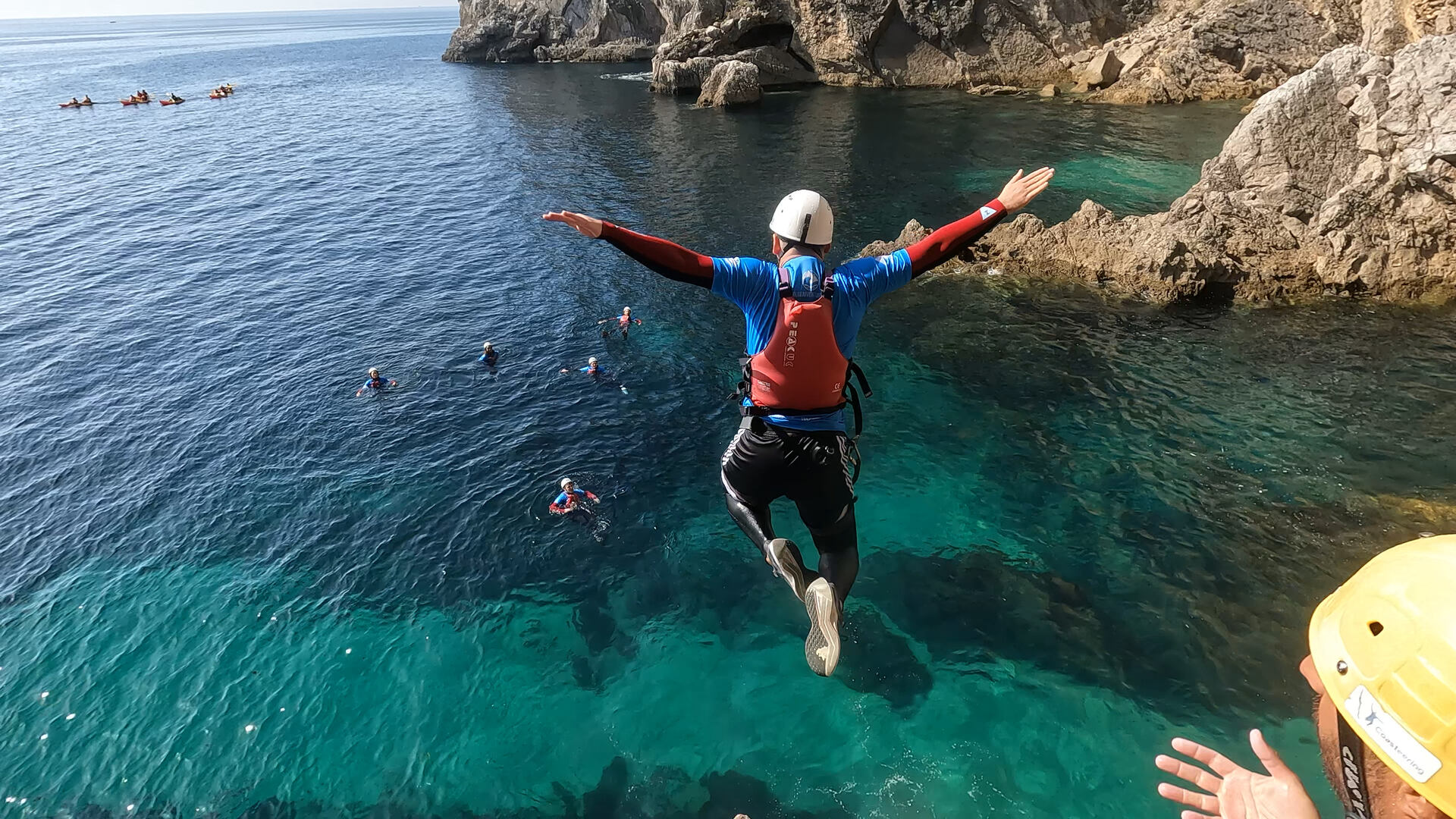 a guy jumping into the sea during a coasteering activity in the Arrabida natural park, Portugal