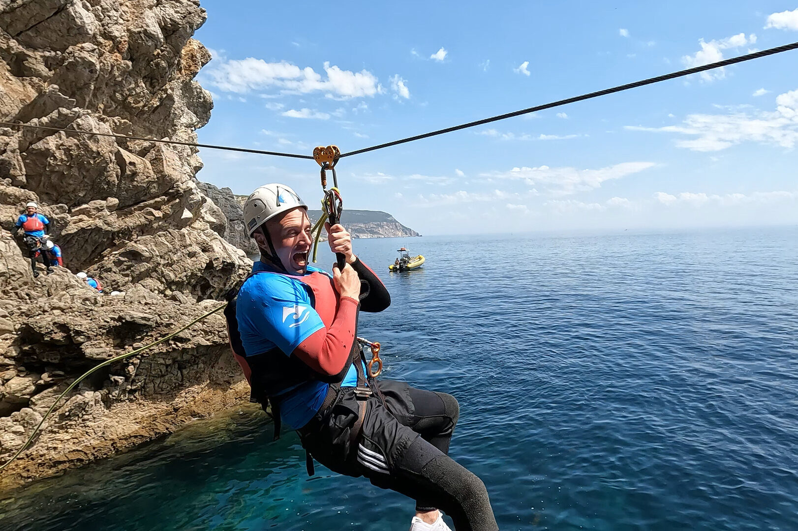 a man ziplining down the coast on a thrilling coasteering activity in Lisbon, Portugal